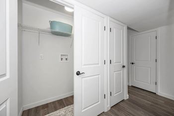 A white door is open to a hallway with a shelf above it.
